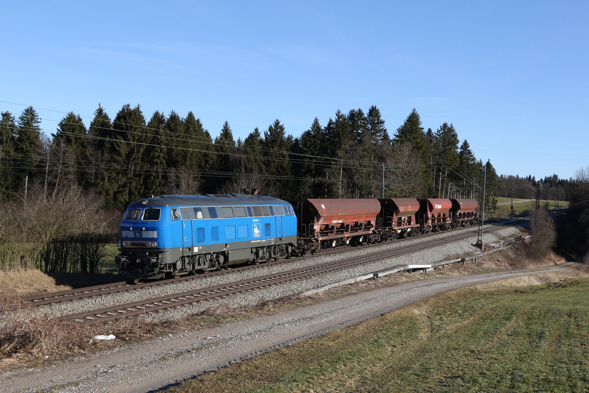 218 054 von  PRESS  mit vier Schotterwagen aus Freilassing kommend am 10. Februar 2022 bei Grabenst�tt im Chiemgau.